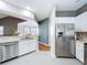 Bright kitchen featuring stainless steel refrigerator, white cabinetry, tile floors, and access to the living area at 776 Grasslands Village Cir # 776, Lakeland, FL 33803
