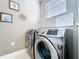 Laundry room featuring front-load washer and dryer, window, and wall decorations at 776 Grasslands Village Cir # 776, Lakeland, FL 33803