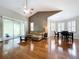 Open-concept living area with hardwood floors, vaulted ceilings, and a dining space with bright natural light at 776 Grasslands Village Cir # 776, Lakeland, FL 33803