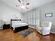 Main bedroom suite with wood floors, ceiling fan, plantation shutters, and a plush recliner at 776 Grasslands Village Cir # 776, Lakeland, FL 33803