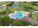 Aerial view of community pool featuring ample seating, shaded tables, and well-maintained landscaping at 776 Grasslands Village Cir # 776, Lakeland, FL 33803