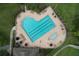 An aerial view of a unique, heart-shaped community pool with lounge chairs and umbrellas at 776 Grasslands Village Cir # 776, Lakeland, FL 33803
