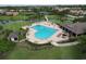 An aerial view of the community pool shows chaise lounges and neatly landscaped surroundings at 776 Grasslands Village Cir # 776, Lakeland, FL 33803