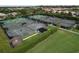 Aerial view of the community tennis courts surrounded by green lawns and palm trees at 776 Grasslands Village Cir # 776, Lakeland, FL 33803