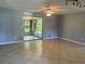 Spacious living room featuring tile floors and ample natural light from a sliding glass door leading to a screened porch at 835 5Th St, Port Orange, FL 32129