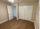 Bedroom with wood floors, closet, open door to another room, and a window with blinds at 1864 Williams Manor Ave, Orlando, FL 32811