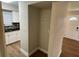 Hallway displaying a view of the front door and a peek into a well-lit kitchen at 1864 Williams Manor Ave, Orlando, FL 32811