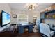 Bright bedroom with a large window, custom blue desk, wood floors, and decorative shelving at 3983 Shay Dr, Bartow, FL 33830
