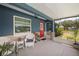 Inviting screened front porch with seating area and a red front door, offering a cozy outdoor space at 3983 Shay Dr, Bartow, FL 33830
