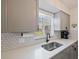 Bright kitchen featuring sleek countertops, stainless steel sink, and modern cabinetry, well lit by the window at 3983 Shay Dr, Bartow, FL 33830