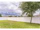 Well-manicured back yard featuring a white vinyl privacy fence, grass and a mature shade tree at 547 Sardinia Cir, Davenport, FL 33837