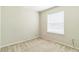 A standard bedroom with neutral walls and carpet, featuring a bright window with white blinds at 547 Sardinia Cir, Davenport, FL 33837