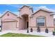 Inviting entrance of a beige home enhanced with white rock landscaping and potted plants at 547 Sardinia Cir, Davenport, FL 33837