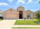 Charming single-story home with a well-manicured lawn and a beige exterior at 547 Sardinia Cir, Davenport, FL 33837