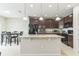 A kitchen features dark brown cabinetry, granite countertops and island, black appliances, and an adjacent dining table at 547 Sardinia Cir, Davenport, FL 33837
