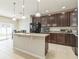 The kitchen features dark cabinets, granite countertops, an island with a sink and eating space, and stainless steel appliances at 547 Sardinia Cir, Davenport, FL 33837