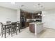 A kitchen and dining area feature dark cabinetry, black appliances, an island with eating space, and pendant lighting at 547 Sardinia Cir, Davenport, FL 33837