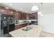Kitchen with dark wood cabinetry, granite countertops, and stainless-steel appliances at 547 Sardinia Cir, Davenport, FL 33837