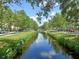 Serene street view with lush greenery, trees, and a canal running through the neighborhood at 539 Water St # 539, Kissimmee, FL 34747