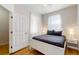 Bright bedroom with a double bed, hardwood floors, and white sheer curtains for natural light and privacy at 5494 Paradise Cay Cir, Kissimmee, FL 34746