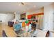 Open-concept living area with a glass dining table, stainless appliances, and stairs to the upper level at 5494 Paradise Cay Cir, Kissimmee, FL 34746