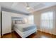 Bright main bedroom featuring tray ceiling, two large windows, built in shelving, and hardwood floors at 5494 Paradise Cay Cir, Kissimmee, FL 34746