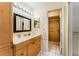 Bathroom featuring a vanity with ample storage, a well-lit mirror, and an adjacent walk-in shower at 62 Lakepointe Cir, Kissimmee, FL 34743