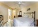 Bright bedroom with tiled floors, ceiling fan, comfortable bed, dresser, and access to bathroom and walk-in closet at 62 Lakepointe Cir, Kissimmee, FL 34743