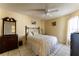 Well-lit bedroom with tiled floors, ceiling fan, comfortable bed, dresser, and window with curtains at 62 Lakepointe Cir, Kissimmee, FL 34743