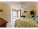 Bright main bedroom featuring tile floors, a ceiling fan, and access to a screened patio at 62 Lakepointe Cir, Kissimmee, FL 34743