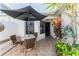 Cozy outdoor patio area featuring tiled flooring, a patio umbrella, and comfortable seating at 62 Lakepointe Cir, Kissimmee, FL 34743