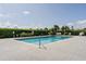Community pool surrounded by lush hedges and lounge chairs, perfect for relaxation and sunbathing at 62 Lakepointe Cir, Kissimmee, FL 34743