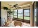 Bright sunroom with ceiling fan, tile floor and large windows offering a serene view of the outdoors at 62 Lakepointe Cir, Kissimmee, FL 34743