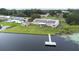 Aerial view shows the lakefront property, private dock, solar panels, fire pit, and well-manicured landscaping at 124 Pangola Dr, Winter Haven, FL 33880