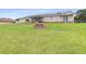 Large backyard featuring a fire pit, covered porch, and a well-maintained lawn at 124 Pangola Dr, Winter Haven, FL 33880