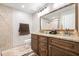 Bathroom with dual sink vanity with granite countertops, large mirror, and tile floors at 124 Pangola Dr, Winter Haven, FL 33880