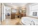 Luxurious bathroom featuring dual vanities, granite countertops, and a corner soaking tub at 124 Pangola Dr, Winter Haven, FL 33880