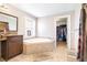 Bathroom with a corner soaking tub, granite vanity, and access to a walk-in closet at 124 Pangola Dr, Winter Haven, FL 33880