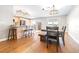 Bright dining room featuring hardwood floors, modern lighting fixtures, and a breakfast bar overlooking the kitchen at 124 Pangola Dr, Winter Haven, FL 33880