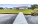 Long wooden dock extending into the lake, perfect for boating and enjoying waterfront views at 124 Pangola Dr, Winter Haven, FL 33880
