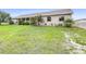 Tan home on a large lot with an extensive, green front yard and garden beds at 124 Pangola Dr, Winter Haven, FL 33880