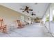 Spacious front porch features multiple ceiling fans and rocking chairs for relaxing at 124 Pangola Dr, Winter Haven, FL 33880