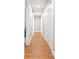 Hallway with wood-look floors, neutral paint, and white doors leading to various rooms in the home at 124 Pangola Dr, Winter Haven, FL 33880