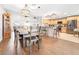 Open concept kitchen with wood floors, stainless steel appliances, breakfast bar, and modern lighting at 124 Pangola Dr, Winter Haven, FL 33880