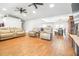Spacious living room with wood floors, ceiling fans, and neutral-colored furniture adjacent to the dining room at 124 Pangola Dr, Winter Haven, FL 33880