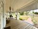 View of the covered front porch with a wood floor, white columns, and a swing at 4145 Willis Rd, Mulberry, FL 33860