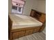 Bedroom featuring a wooden bed frame with drawers and storage, next to a window for natural light at 12828 Sw 49Th Ter, Webster, FL 33597