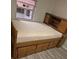 Bedroom with window and wooden bed that has drawers and headboard storage at 12828 Sw 49Th Ter, Webster, FL 33597