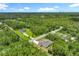 Aerial view showcasing the home nestled amidst lush greenery, with a long driveway leading to the property at 19041 Mardi Gras St, Orlando, FL 32833