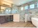 Modern bathroom featuring stylish tile, sleek glass shower, soaking tub, and contemporary vanity at 19041 Mardi Gras St, Orlando, FL 32833